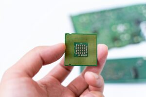 IC CPU in hand with PCB board background. Concept of Technology computer and hardware computer.